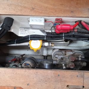 Onder de vloer voor de kajuittrap. De nieuwe sensor is geel. De wasmachineafvoerslang is wit.