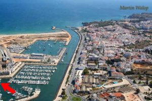Lagos uit de lucht. Onze boot ligt helemaal linksonder bij de rode pijl, de steiger staat nét niet op de foto. In het midden de ophaalbrug voor voetgangers. Het centrum van de oude stad is rechts