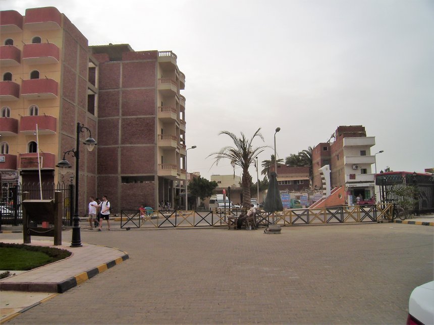 Hurghada. Een van de drie toegangen tot het toeristencomplex. De bewakers zitten in het midden, buik vooruit, onder het palmboompje