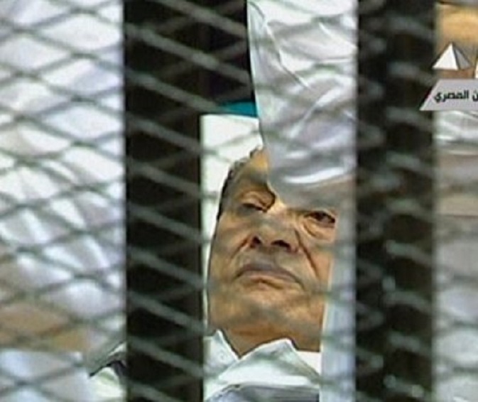 Hosni Mubarak op zijn bed voor zijn rechters in Caïro (beeld AP)