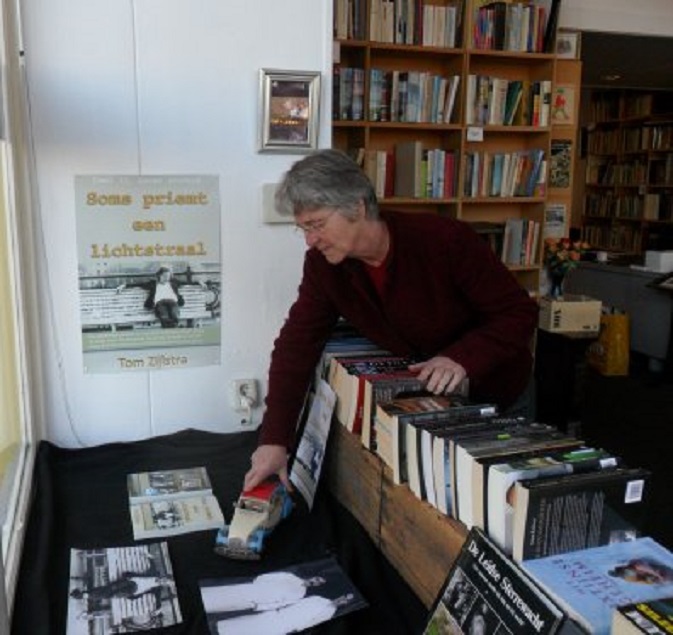 Joke richt de etalage met deel 2 in van Antiquariaat Gorcum. Let op het 2CV-model.