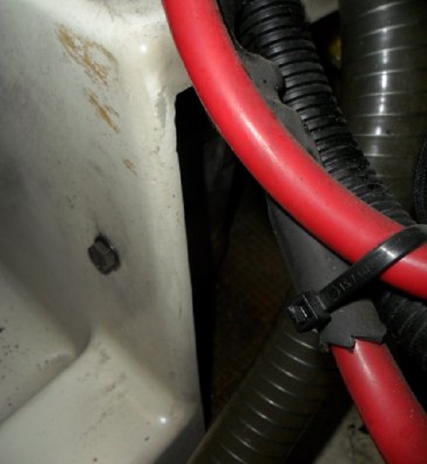 Het rechthoekige gat aan de voorkant van de bakboord motorsteun. Hierdoor zou je het waterslot eruit moeten kunnen trekken.