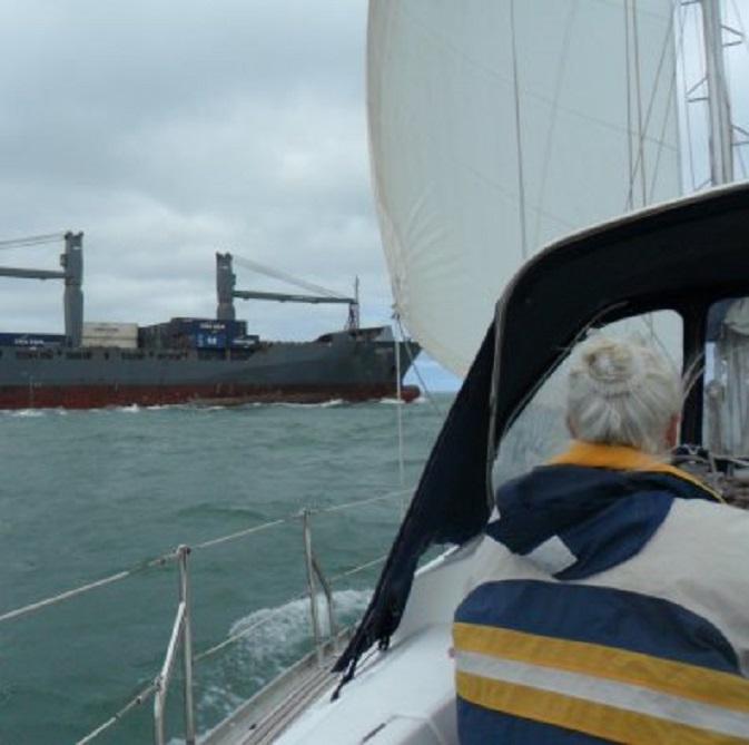 Containerschip 'Violetta' draait vlak voor ons langs naar stuurboord bij de invaart van de industriehaven bij Dunkerque