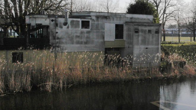 Het verkrottende Café Genesis op Buiten de Waterpoort (foto AD) Hiervoor in de plaats zou de abjecte pisgele hoteldoos moeten komen.