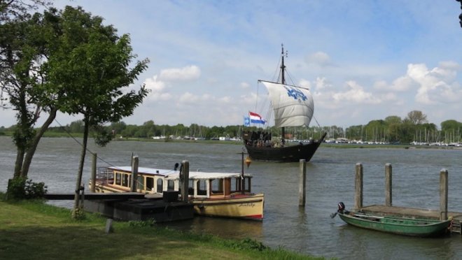 De Kamper Kogge onder zeil op de IJssel voor Kampen. Op de achtergrond de jachthaven van Seveningen, waar we liggen. (foto: kamperkogge.nl)