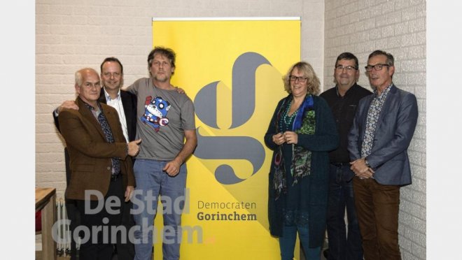 De initiatoren van de nieuwe lokale beweging Democraten Gorinchem bij hun logo. Vlnr. Toon Mik, Pierre Schefferlie, Ro van Doesburg, Tamara Hoogesteder, Kees van Willigen en Ries Pauk (foto: De Stad Gorinchem).