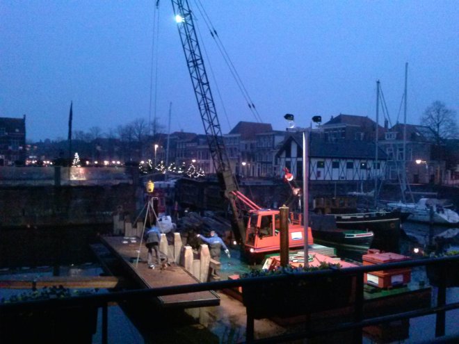 Werk aan verandering van het remmingwerk bij de sluis. Zie op de achtergrond de kerstbomenbrug over de waterkering van buurtvereniging KNAKE (foto van eergisteren).
