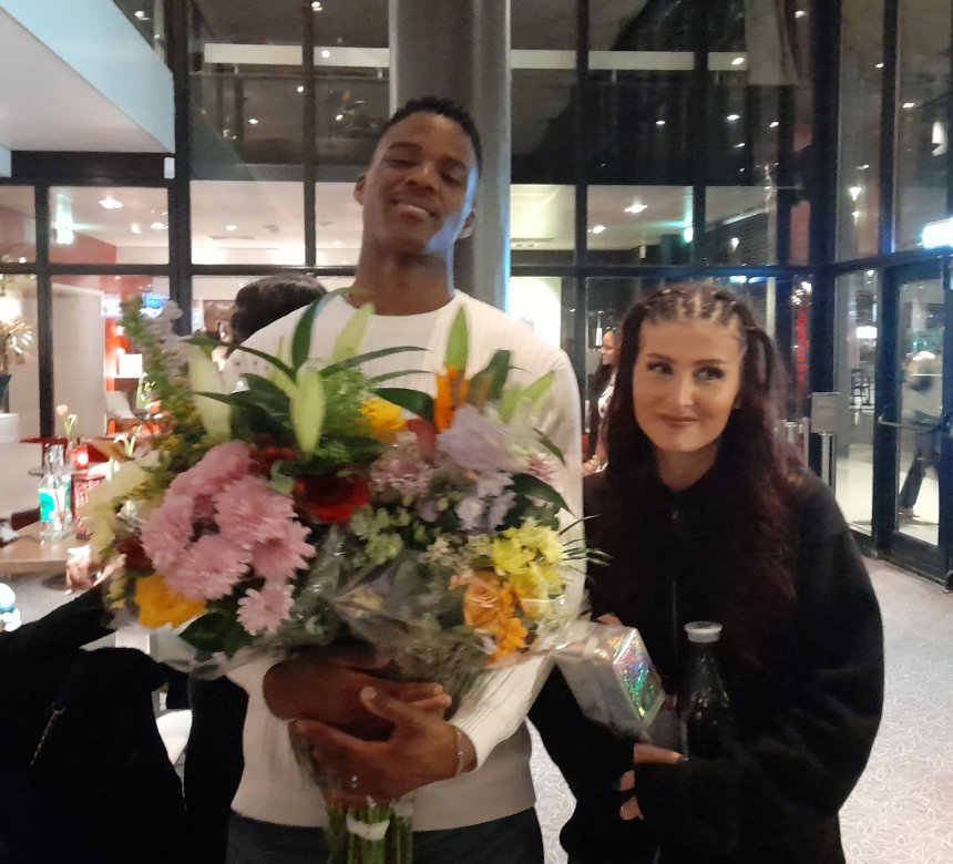 De trotse danseres Esri in de hal van het Isala Theater in Capelle a/d IJssel. Haar vriend Ruiz draagt de bouquetten.